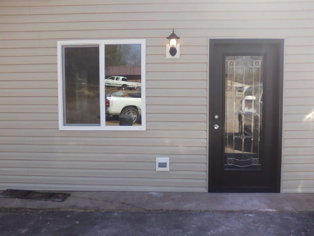 New siding, window and entry door on the side of an addition in Milton